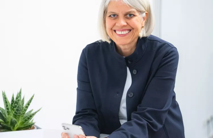 Steichele-Guntrum lehnt lächeld am Tisch.